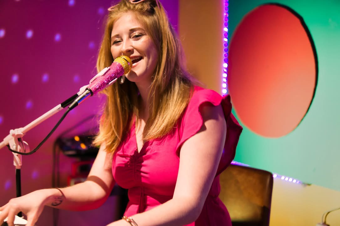 Maggie Moon performing at a colorful dueling-pianos show